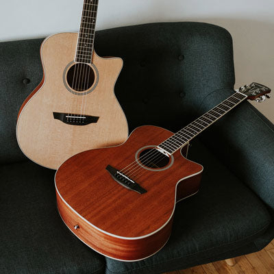 Rey spruce and Rey mahogany guitars on a green sofa